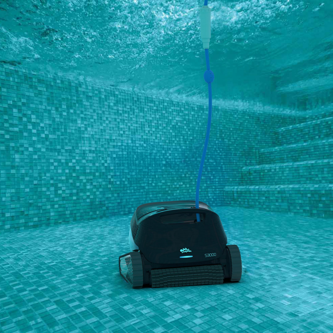 Underwater front elevation view of the Maytronics Dolphin S3000 robotic pool cleaner resting on a blue mosaic tiled pool floor near steps, highlighting its active front scrubbing brush, illuminated LED light bar, dark navy body casing, and blue power cable rising to the surface.