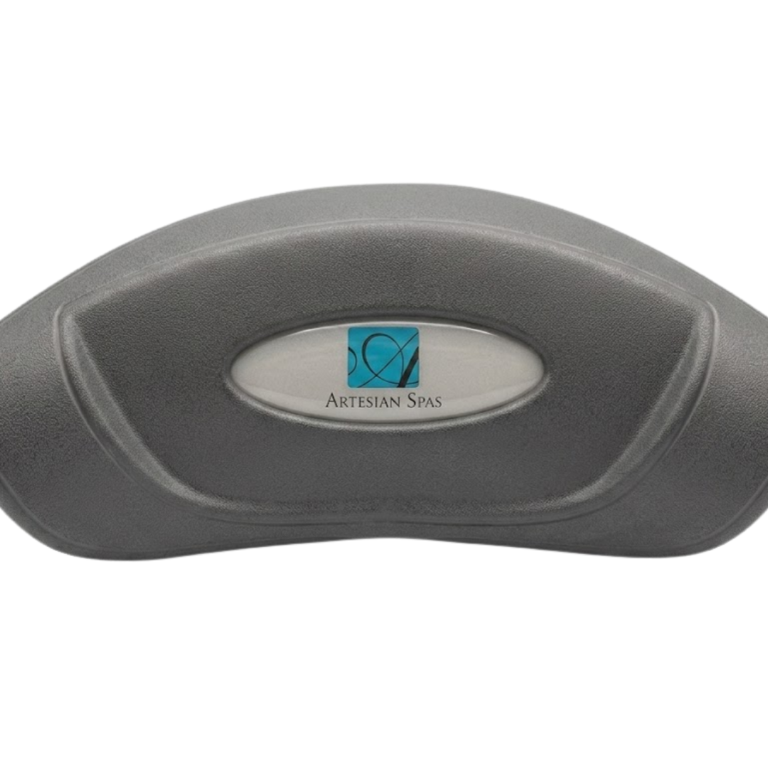 Front product view of a grey curved foam replacement headrest pillow for an Artesian Spas hot tub, complete with the oval metallic silver logo dome label installed in the center indentation.