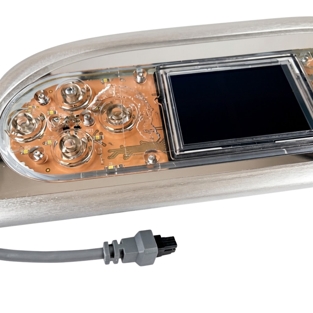 Close-up view of an Artesian Spas TP800 Island Spas touchpad panel showing screen, internal button contacts, metallic bezel, and connector plug.