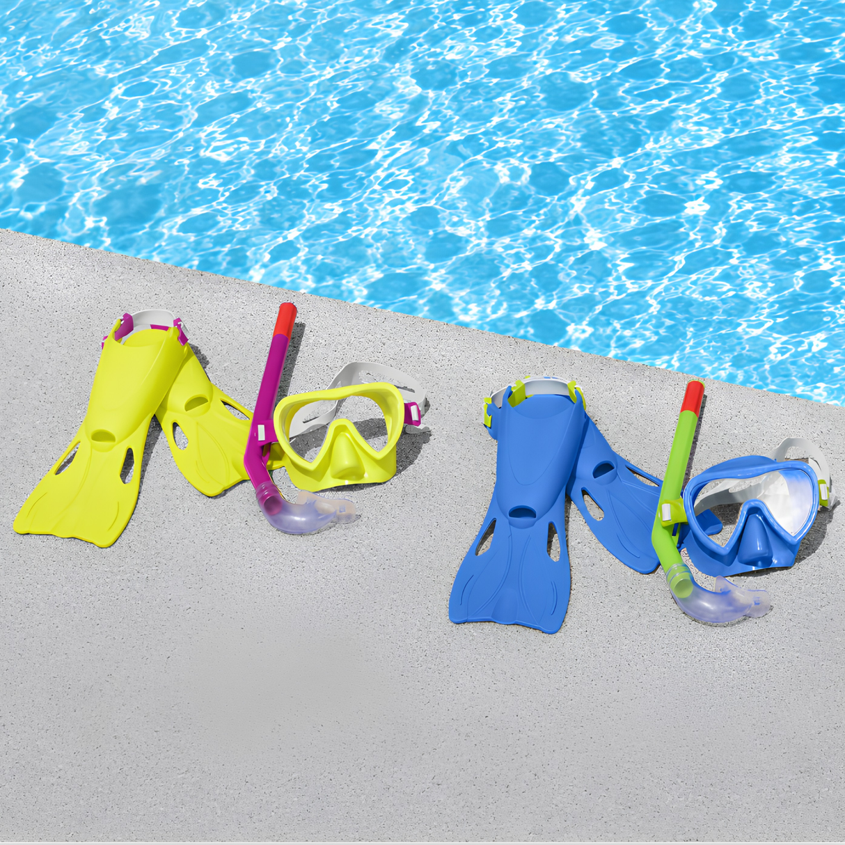 Two Bestway Hydro-Swim Lil Flapper kids snorkel sets in assorted yellow-purple and blue-lime-green color options laid out on a concrete pool edge next to clear blue swimming pool water.
