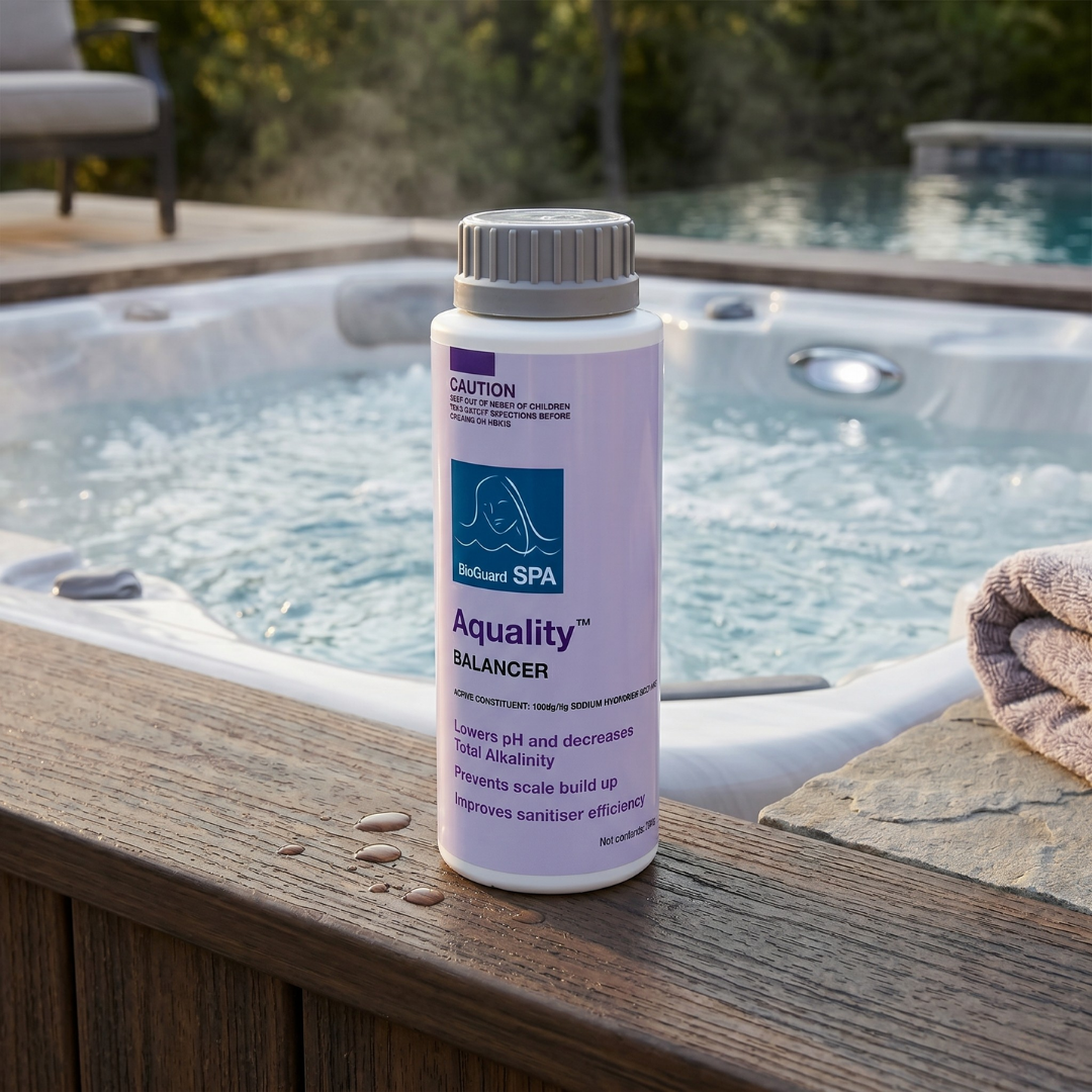 A 750g bottle of BioGuard Spa Aquality balancer sitting on a wooden hot tub deck next to bubbling water, used as a dry acid to lower pH, decrease total alkalinity, and prevent scale build-up.