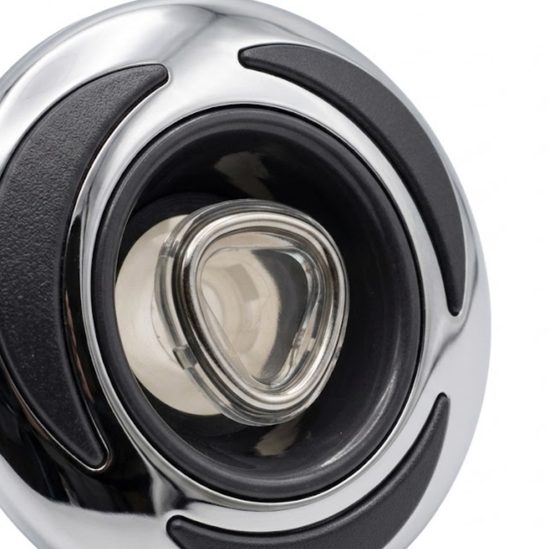 Close-up view of the central eyeball-style directional nozzle on a C-Helix 3 Directional SS spa jet internal insert, showing the rounded triangular clear nozzle trim set inside a stainless steel bezel with textured black crescent accents.