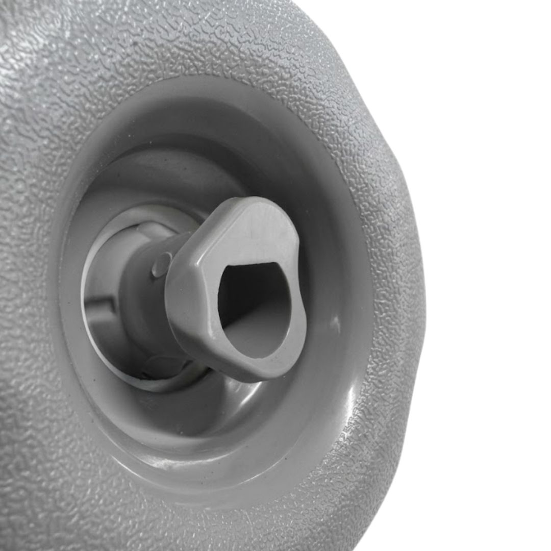 Close-up angled view of the central adjustable swirl nozzle and grey internal housing on a Jet Cyc Luxury Adj Swirl Emerald 3.5 spa jet insert, showing the textured light grey outer bezel.
