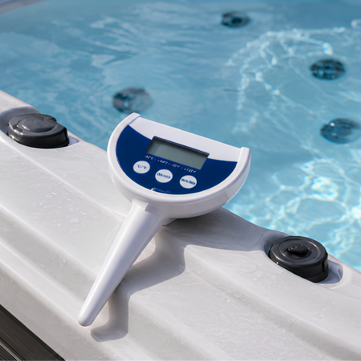 A white and blue Life Spa Essentials floating digital thermometer resting on the molded white acrylic edge of an outdoor hot tub, with clear blue water and spa jets visible in the background