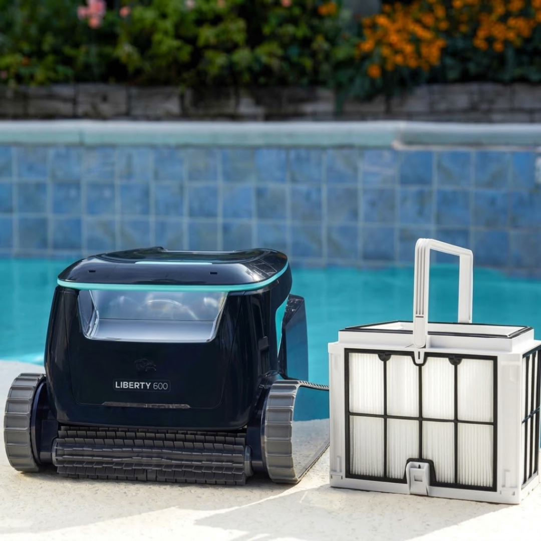 Front lifestyle view of the Maytronics Dolphin Liberty 600 robotic pool cleaner sitting poolside next to its detached, large ultra-fine filter basket with carrying handle.