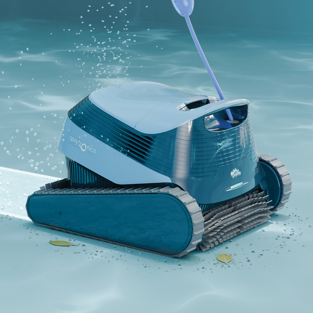 Underwater action shot of the Maytronics Dolphin S1000 robotic pool cleaner actively scrubbing the pool floor, showing its front spinning brush sweeping up fine debris and leaves, continuous rubber tracks, light blue top casing, Maytronics branding, and rear water jet propulsion.