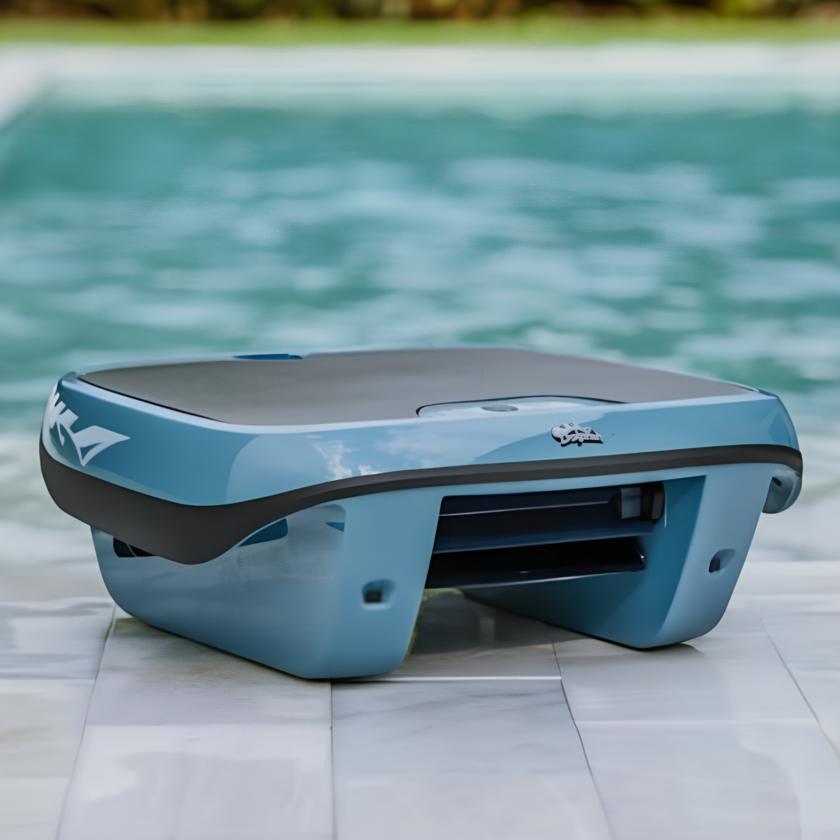 A grey and black Maytronics Dolphin Skimmi 300 solar-powered pool skimmer sitting on a tiled pool deck next to clear water