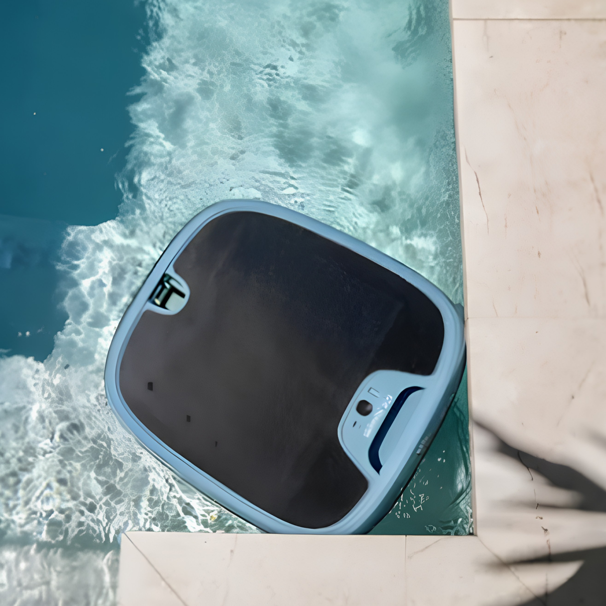 Top-down view of a grey Maytronics Dolphin Skimmi 300 solar pool robot navigating a 90-degree corner along a stone pool coping edge.