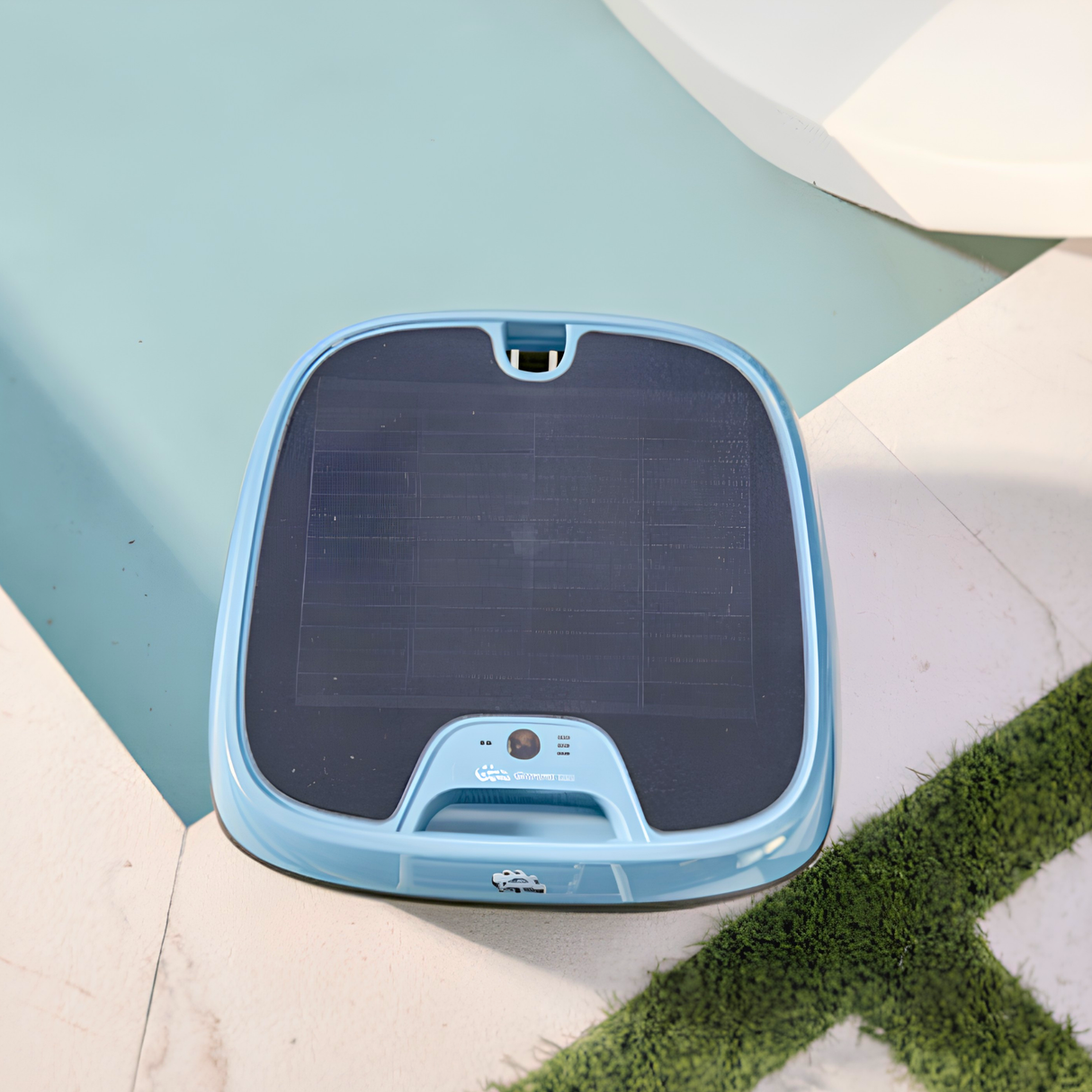 Top-down view of the light blue Maytronics Dolphin Skimmi 300 solar pool cleaner showcasing its large overhead solar charging panel sitting by the pool edge
