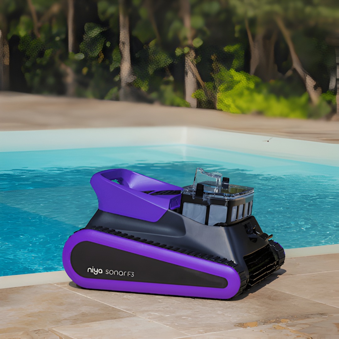 Lifestyle product view of a purple-accented Maytronics Niya Sonar F3 robotic pool cleaner sitting on a tiled patio next to a swimming pool with its top filter compartment open, exposing the clear filter basket.
