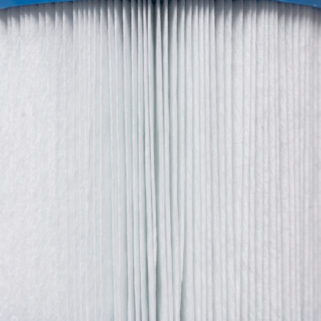 Macro texture close-up of the fine white pleated fabric media on an SQ50 replacement filter element for square basket skimmers