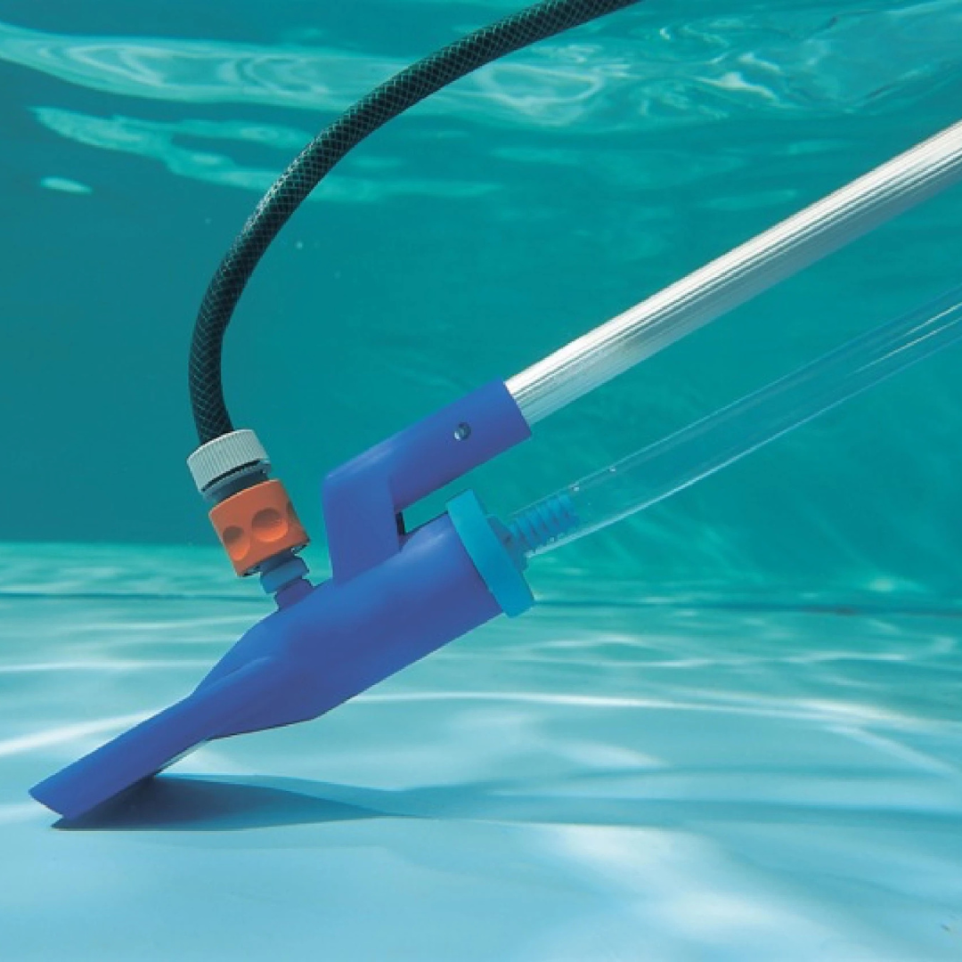 Close-up underwater view of the Swimsafe Supa-Vac setup as a venturi pump, showing a garden hose attached with an orange connector and a clear drainage hose siphoning water from a clean swimming pool floor.