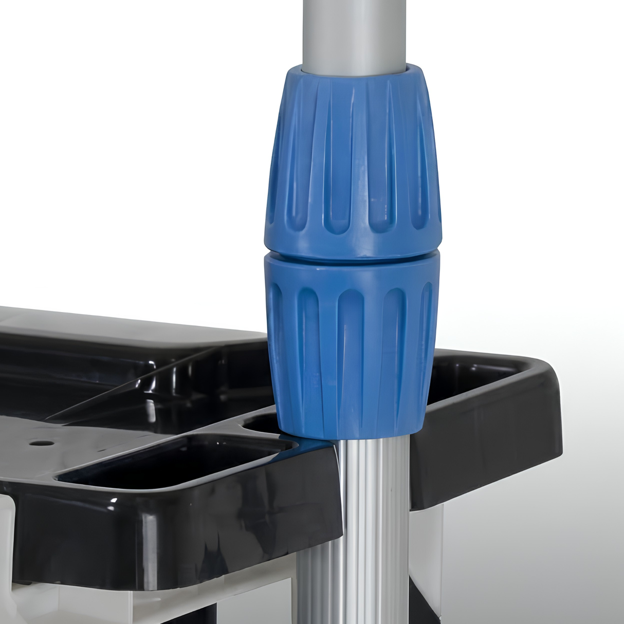 A close-up view of a ribbed blue locking collar on an aluminum telescoping pole resting inside the dedicated vertical storage slot of The Rack pool accessory organizer tray