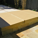 A sandstone three-piece custom swim spa hard cover installed over a pool on a sandstone paved patio.