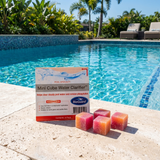 BioGuard Mini Cube Water Clarifier blocks for swimming pools, shown on a poolside ledge with crystal clear water in the background; suitable for sand, glass, and zeolite filters.