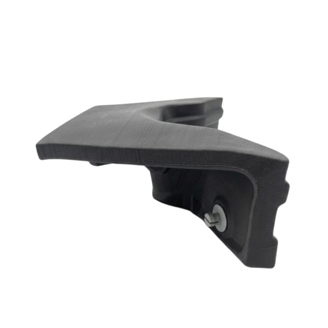 High-angle side perspective view of a charcoal black replacement neck headrest pillow for an Artesian Elite spa, showcasing the top textured surface contour and under-mount grey clip pin on a white background.