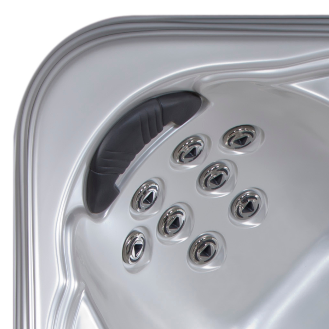High-angle view of an Artesian Spas Island series charcoal grey waterfall headrest pillow mounted inside a contoured silver acrylic hot tub shell above an eight-jet hydrotherapy configuration.