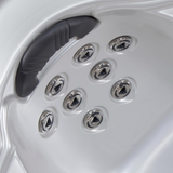 Angled view of multiple Artesian C-Helix 2.75 SS spa jets installed in an array below a padded headrest within a white acrylic hot tub shell.