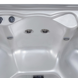 Wide view of two Artesian C-Helix 3 ROTO SS spa jets installed inside the wall of a white acrylic hot tub shell.