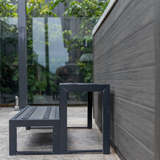 Black Artesian modular aluminium 2-tier spa steps placed next to a modern hot tub in an outdoor backyard patio setting.