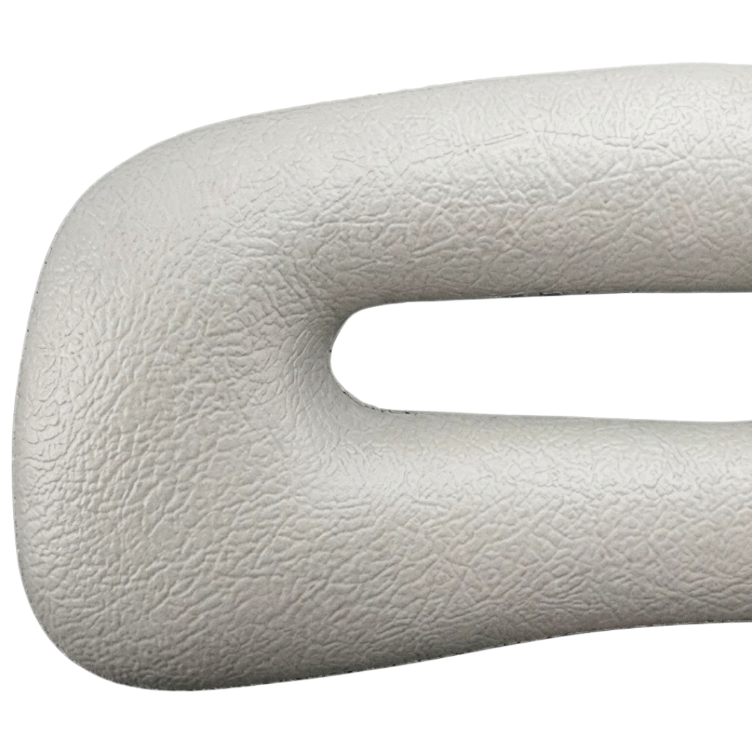 Close-up texture view of a grey foam replacement lounge waterfall headrest pillow for an Artesian Platinum Elite hot tub, focusing on the left contour edge and faux-leather grain finish around the slot opening.