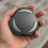 A person holding a graphite gray Artesian Spas 2-inch hot tub diverter valve replacement knob (OP08-1360-52C) in their hand to demonstrate the physical scale and size of the part.