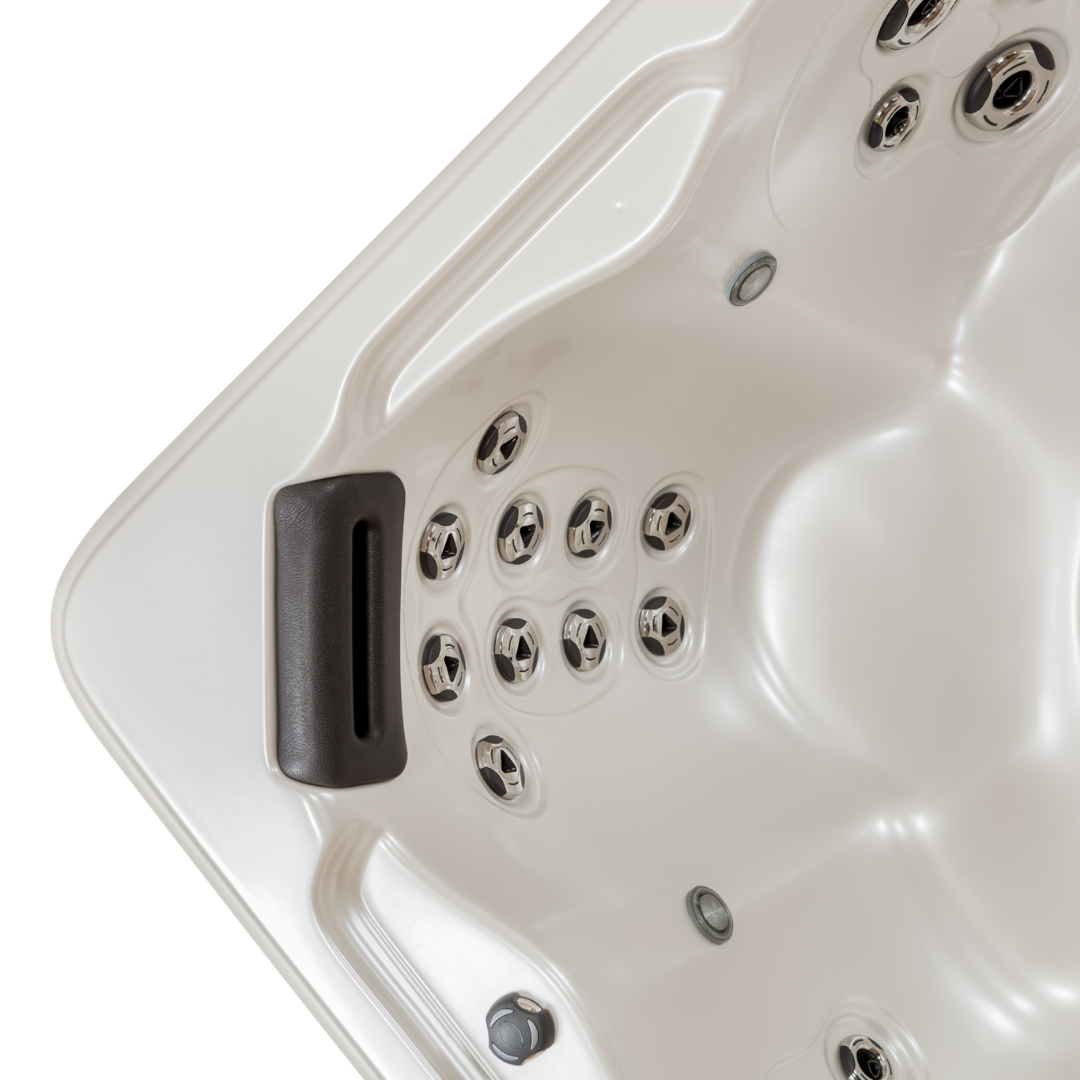 Overhead view of an Artesian Spas Island series 8-inch waterfall headrest pillow in charcoal gray installed inside a white hot tub shell near rows of massage jets.