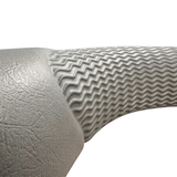 Macro close-up of an Artesian Spas Island series wrap headrest pillow, detailing the textured gray faux-leather material and the molded wavy grip pattern.