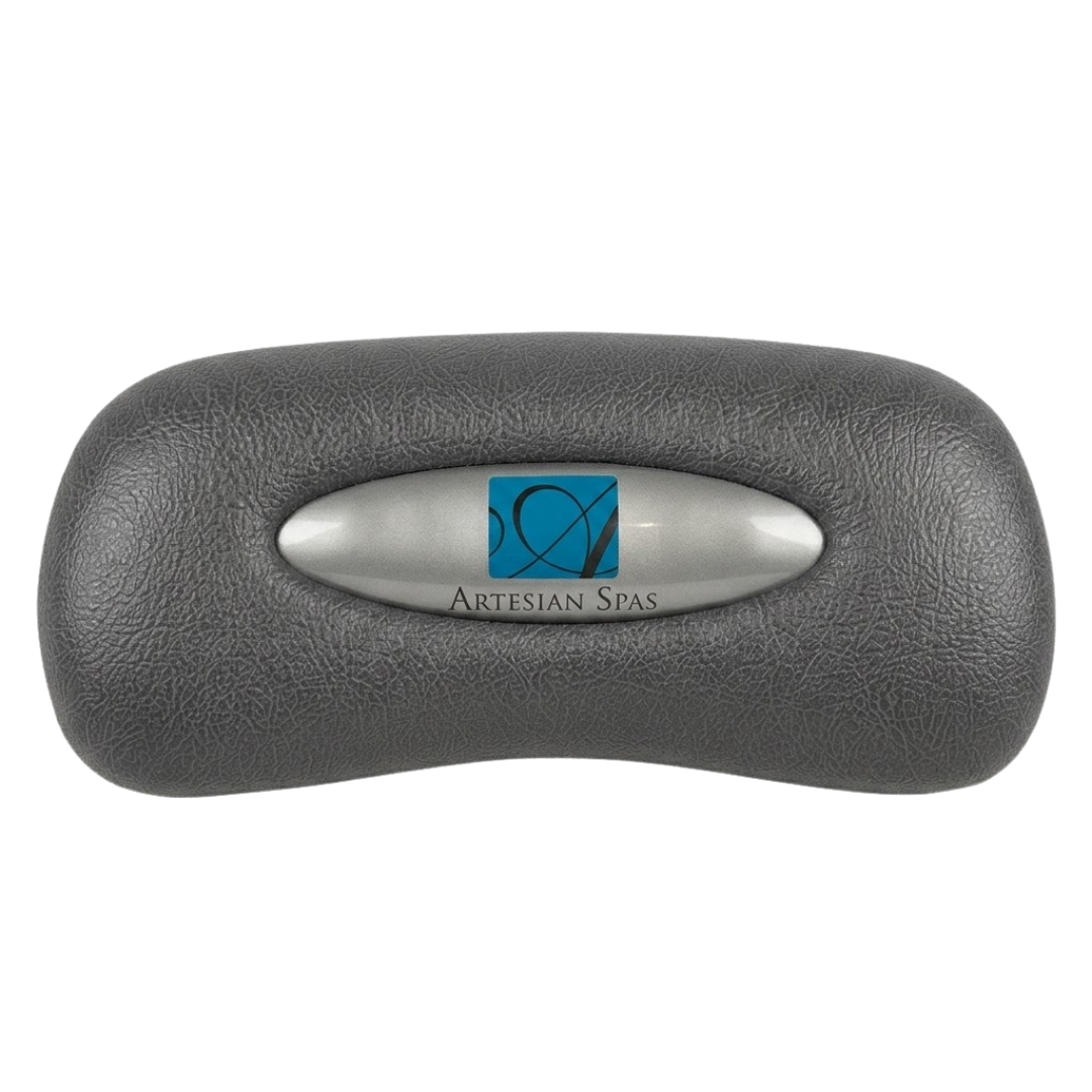 Front view of an Artesian Spas Platinum Elite series replacement 11-inch headrest pillow in dark charcoal gray featuring an oval silver insert with the blue Artesian Spas logo.
