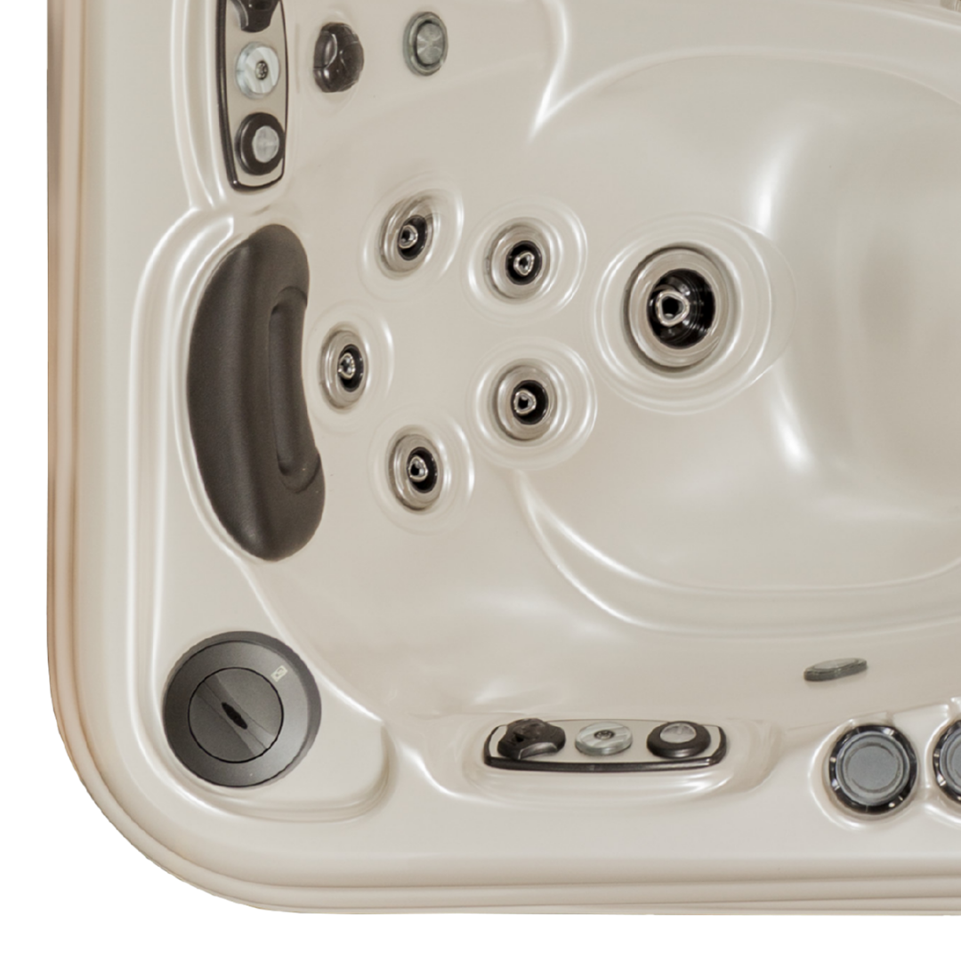 Top-down overhead view of an Artesian Spas Platinum Elite series 12-inch waterfall headrest pillow in dark charcoal gray installed in a corner seat configuration of a cream-colored hot tub.