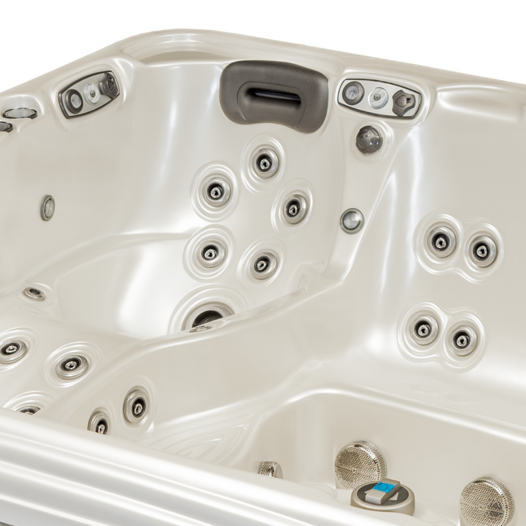 Overhead view of an Artesian Spas Platinum Elite series 12-inch waterfall headrest pillow in dark charcoal gray installed inside a cream-colored hot tub corner above rows of massage jets.