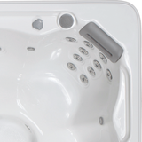 Overhead view of an Artesian Spas South Seas and Tropic Seas series 8-inch waterfall headrest pillow in light gray installed inside a white hot tub corner above rows of massage jets.