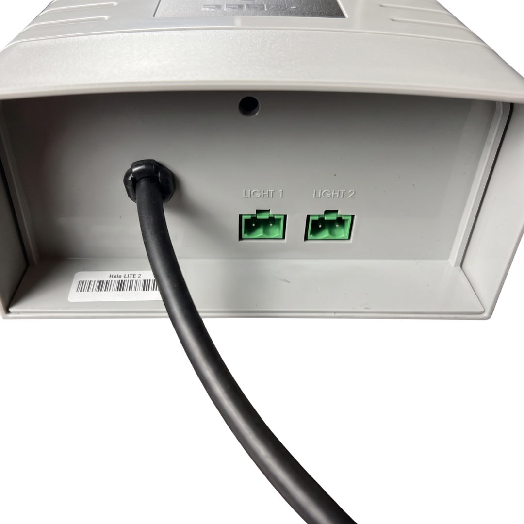 Underside view of an AstralPool Halo Lite 2 controller showing the black power cable entry, a product barcode label, and two green plug ports labeled Light 1 and Light 2.