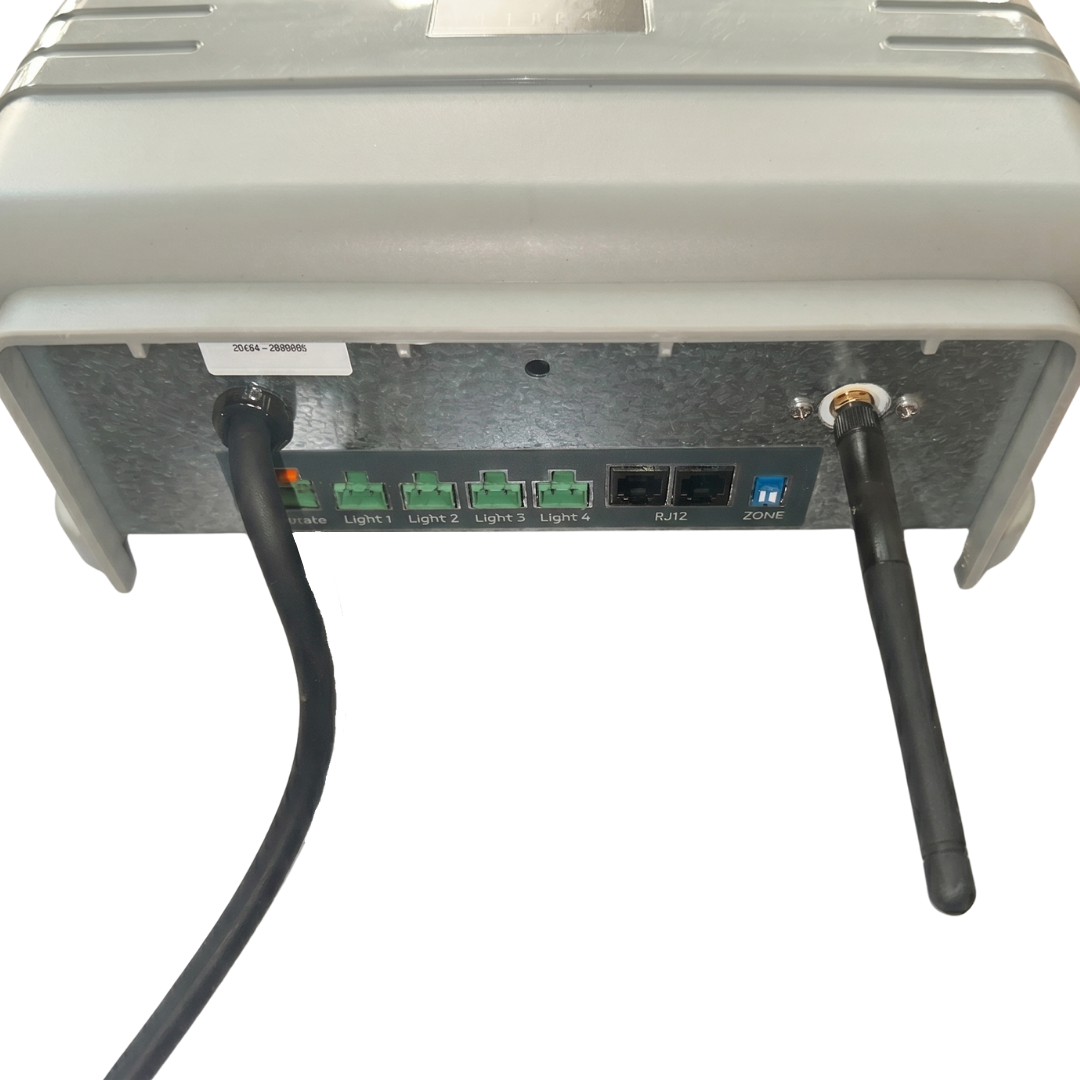 Underside view of an AstralPool Halo Lite 4 controller showing a black power cord, four green ports labeled Light 1 through Light 4, two RJ12 ports, a zone switch, and an attached black wireless antenna.