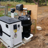 Outdoor pool equipment pad installation featuring an AstralPool Viron QL540 cartridge filter alongside a white pool inverter heat pump and connected PVC plumbing