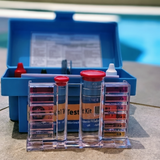 Detailed view of an Aussie Gold 4-in-1 test kit comparator block poolside, displaying integrated color scales for measuring pH, Chlorine, Bromine, and Acid Demand in swimming pools and spas.