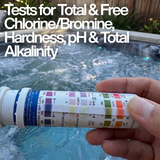 Close-up of a hand holding an Aussie Gold QuikChek5 test strip against the bottle chart with text: "Tests for Total & Free Chlorine/Bromine, Hardness, pH & Total Alkalinity."