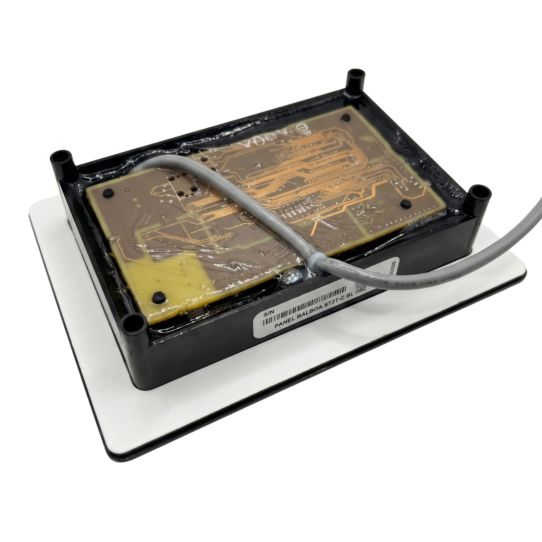 Angled view of the back of a Balboa SpaTouch 2 ST2T-C topside control panel, featuring the serial number barcode label, clear resin-coated circuit board, and plastic mounting posts.
