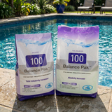 Two bags of BioGuard Balance Pak 100 Total Alkalinity Increaser in 2kg and 4kg sizes sitting poolside, used to stabilize pH levels and improve swimmer comfort in chlorine and salt pools.