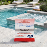 BioGuard Filter Brite pool chemical sachet sitting on a stone coping deck next to an integrated backyard swimming pool and bubbling hot tub spa.