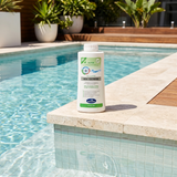 A bottle of BioGuard MSA Extreme Pool Algaecide sitting on a travertine pool edge next to crystal clear, sparkling blue water, showcasing professional pool maintenance results.