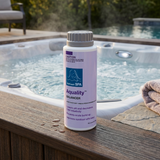 A 750g bottle of BioGuard Spa Aquality balancer sitting on a wooden hot tub deck next to bubbling water, used as a dry acid to lower pH, decrease total alkalinity, and prevent scale build-up.