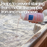 A person is pouring a light pink liquid chemical, identified as BioGuard SPA Defence, from a white bottle into the bubbling, steamy water of a hot tub.