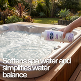 A hand pouring BioGuard Spa Perfect Balance into a bubbling hot tub with text: "Softens spa water and simplifies water balance," showing the liquid water conditioner in use.