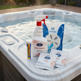 A BioGuard Spa Water Resuscitation Kit, including QuikChek 5 test strips, Filter Renew spray, a Life Spa Disc, and two Purity oxidiser packets, sitting on the corner ledge of an outdoor hot tub.