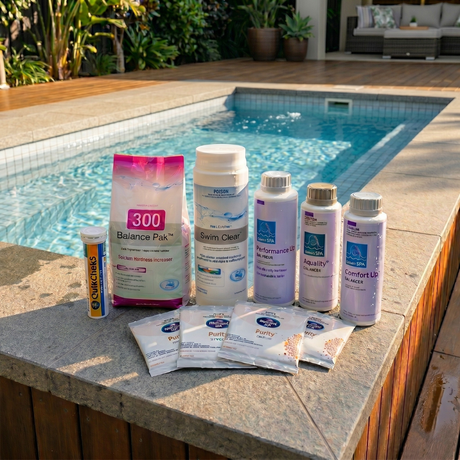 BioGuard chlorine plunge pool water care kit featuring Swim Clear, Balance Pak 300, Performance Up, Aquality, Comfort Up balancers, Spa Purity sachets, and QuikChek5 test strips arranged on a stone ledge next to an outdoor plunge pool.