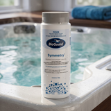750g bottle of BioGuard Symmetry Bromine Sanitiser Tablets sitting on the ledge of an indoor spa, showing a low-odour alternative to chlorine for hot tubs.