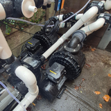 Field installation photo of multiple Davey Hurricane H300M Turbo spa pumps integrated into a pool and spa equipment setup, showing complex PVC pipework, valves, unions, and electrical wiring on a wet concrete pad.