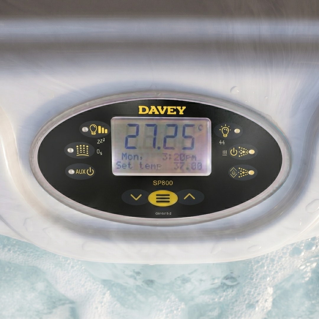 Front view of an operational Davey SP800 oval spa touchpad controller mounted on a white marbled hot tub rim, showing an illuminated digital reading of 27.25°C on its LCD display screen above churning spa water.