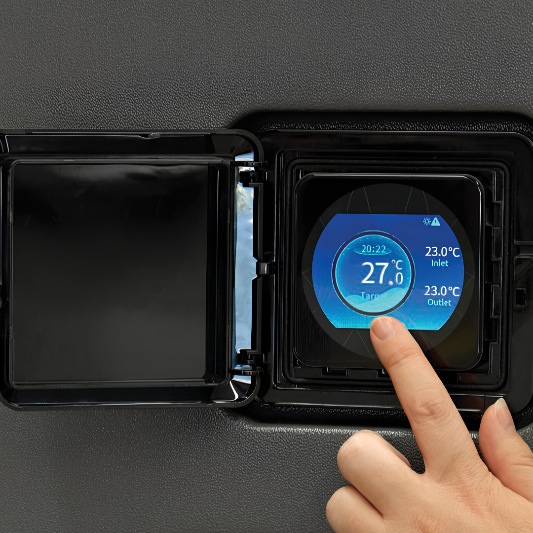 Close-up view of a hand interacting with the circular digital touchscreen control panel of an EvoHeat Fusion-iPro series pool heat pump, housed behind an open square protective hatch on the textured grey casing.